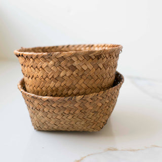 Two woven baskets stacked on a marble surface