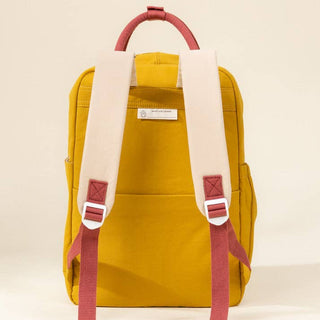 Yellow backpack with red straps on a beige background
