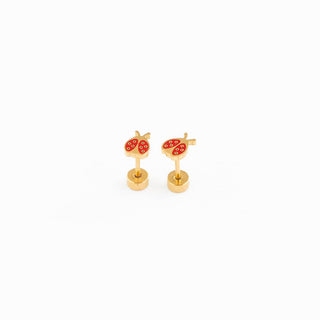 Gold earrings with red heart designs on a white background