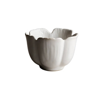 White ceramic bowl with scalloped edge on a gray surface