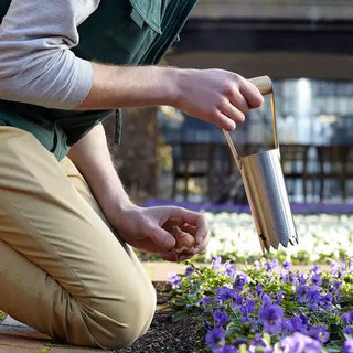 Person gardening with a trowel in a garden setting
