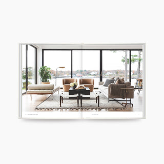 Modern living room with furniture and large windows.