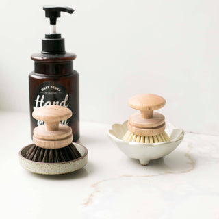 Set of cleaning products including a bottle, brush, and scrubber on a white background