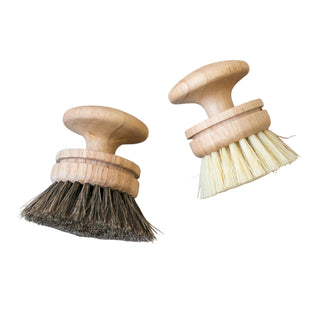 Two wooden brushes with bristles on a striped towel
