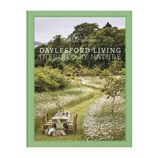 Book cover of 'Daylesford Living Inspired by Nature' with a scenic view of a garden and table.