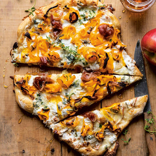Cheesy pizza with slices cut on a wooden board