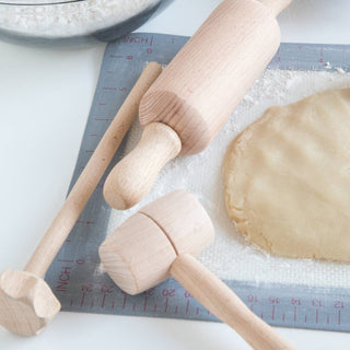 Wooden rolling pins on a surface with flour and dough