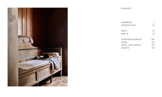 Wooden bed in a room with a table and chair, next to a table of contents for a book.