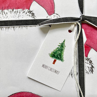 Gift bag with pink and black design featuring a Christmas tree tag.