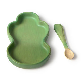 Green leaf-shaped plate and matching wooden spoon on a white background