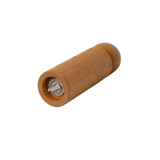 Wooden pepper grinder on a beige surface