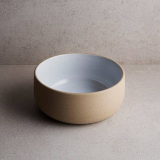 Beige ceramic bowl on a gray surface with a neutral background