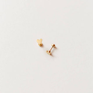 Gold heart-shaped earrings on a light gray background