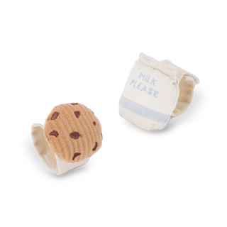 Two baby items: a cookie-shaped rattle and a bib with 'Milk Please' text on a white background.