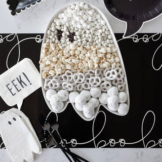 Halloween-themed popcorn arrangement shaped like a ghost on a black plate with 'BOO' text.