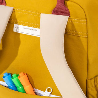Yellow backpack with colorful markers in a pocket, featuring a visible brand label.