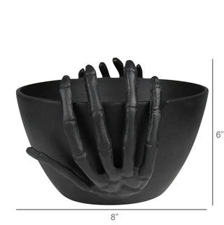 Black bowl with skeleton hand design on a white background