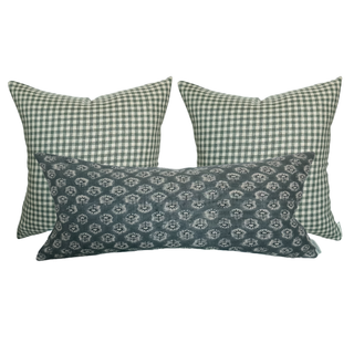 Three decorative pillows with green checkered and blue patterned designs on a white background.