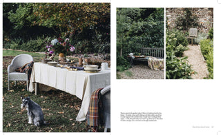 Outdoor setting with a table set for a meal, a dog, and a garden view.