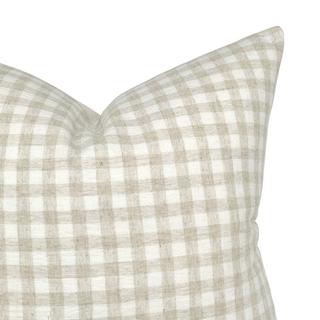 Close-up of a checkered pillow with a beige and white pattern on a white background