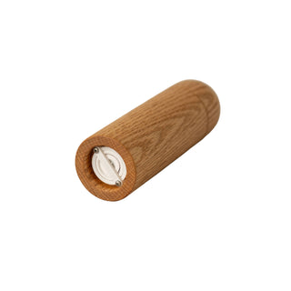 Wooden pepper grinder on a beige surface