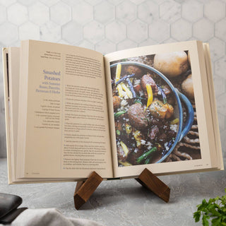 Open cookbook on a stand with a recipe for Sautéed Potatoes displayed, set against a kitchen background.