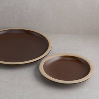 Two brown ceramic plates on a gray surface