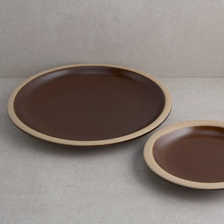 Two brown ceramic plates on a gray surface