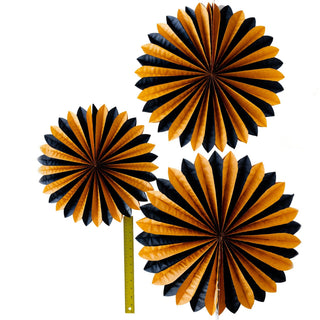 Three black and gold paper fans on a white background
