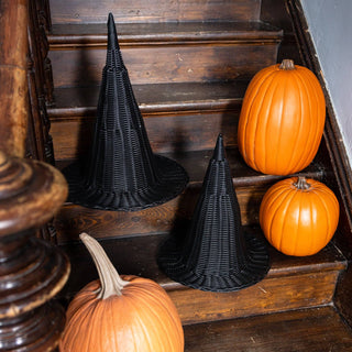 Black witch hats and orange pumpkins on a wooden staircase