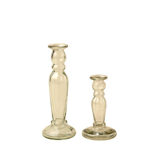 Two clear glass candle holders on a beige background