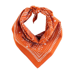 Orange bandana with white patterns on a light gray background