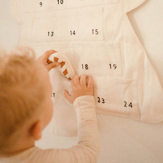 Child playing with a calendar showing numbers on a light background
