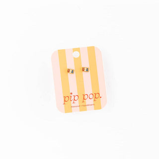 Pip Pop earrings on a striped card with 'pip pop' branding on a white background