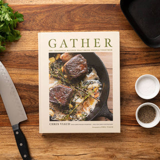 Cookbook titled 'Gather' by Chris Yeld on a wooden surface with ingredients and utensils.