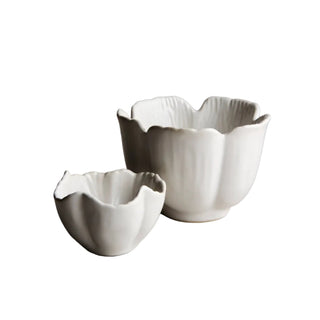 Two white ceramic bowls on a gray surface with a neutral background