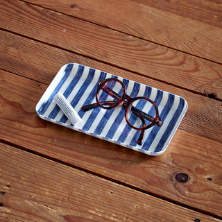 Blue and white striped tray with glasses on a wooden surface