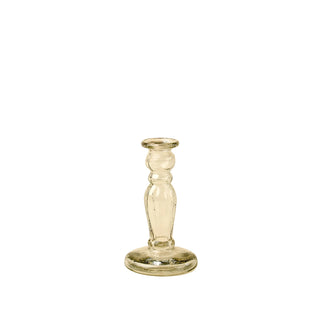 Clear glass candlestick holder on a beige background