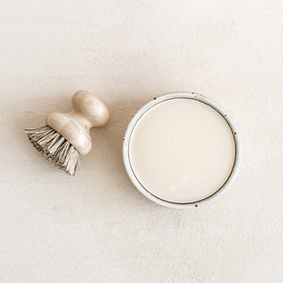 Round mirror and brush on a light beige surface