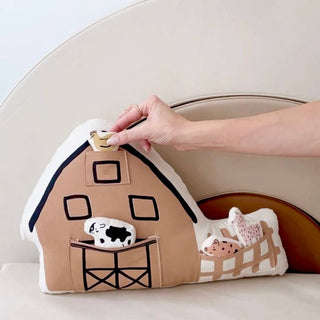 Barn-shaped pillow with cartoon animals on a white background