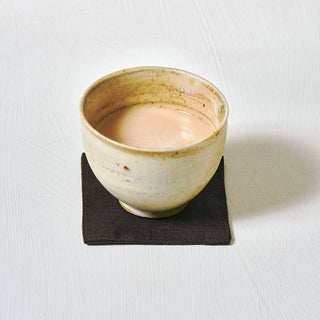 Ceramic cup with a light-colored beverage on a white background
