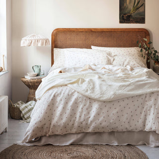 Bedroom with wooden headboard, white bedding, and wall art.
