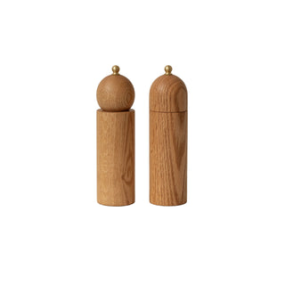 Two wooden salt and pepper shakers on a beige background