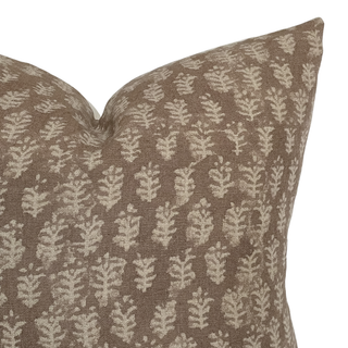 Decorative pillow with leaf pattern on a brown background