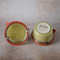 Two containers with green contents on a beige surface
