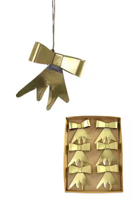 Gold bow-shaped ornament hanging from a string on a white background