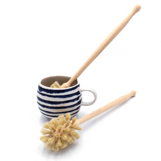 Striped mug with wooden and natural fiber scrubber on a white background