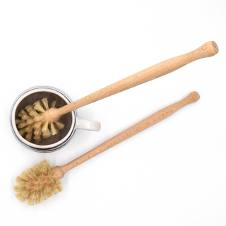 Two wooden dish brushes with natural bristles on a white background