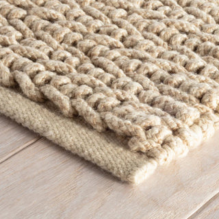 Textured beige rug on a wooden floor