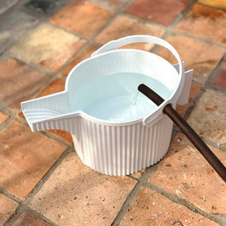 White plastic bucket with a handle on a tiled floor